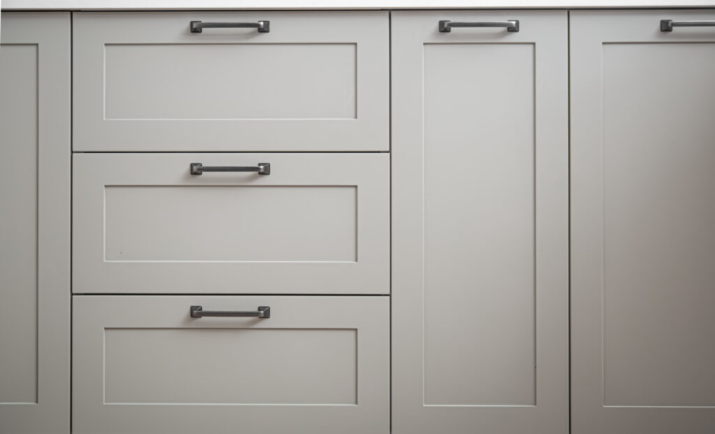 White kitchen cabinets with metal pulls or knobs on the doors.