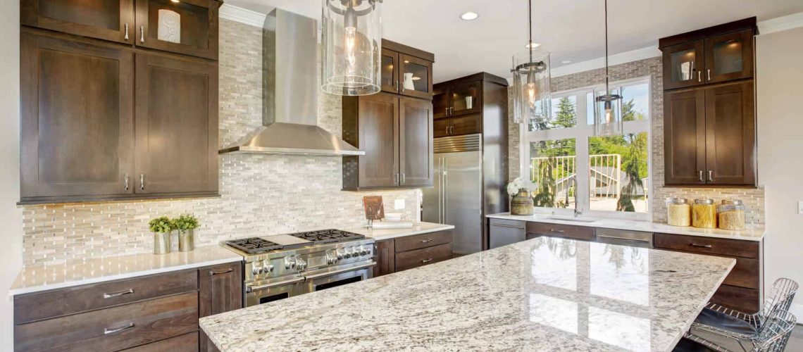 Luxury kitchen accented with large granite kitchen island, taupe tile backsplash, natural brown wood cabinets and lots of natural light. Northwest, USA