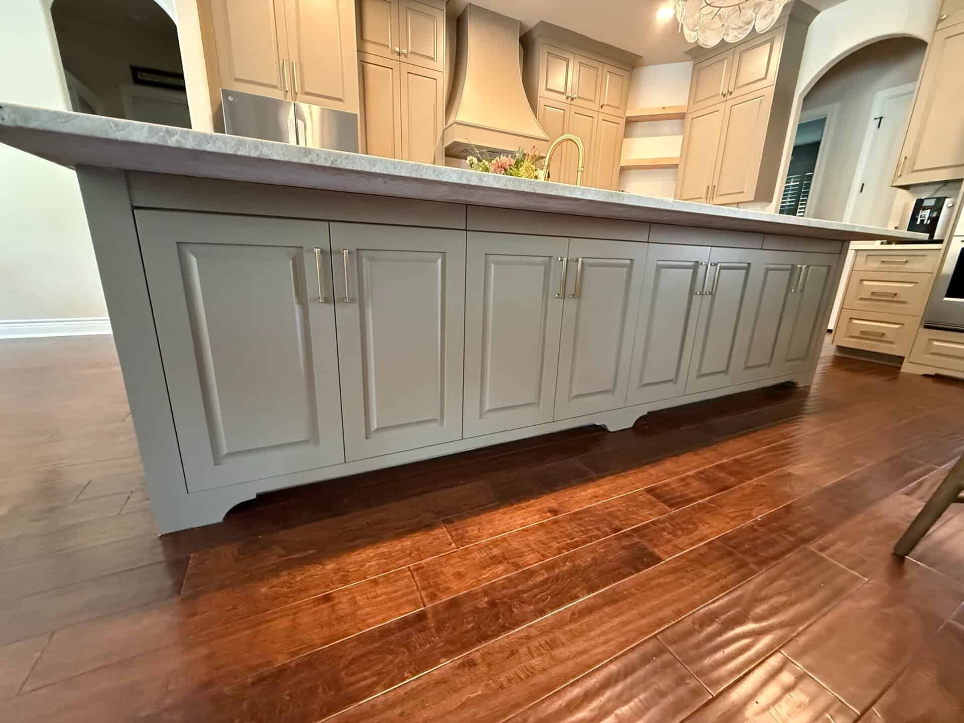 Custom kitchen island with raised-panel cabinets, brass pulls and quartzite countertop by LuxeCraft in San Antonio