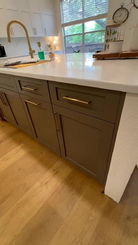 Custom kitchen island with taupe Shaker cabinets, brass pulls and white quartz countertop by LuxeCraft in San Antonio