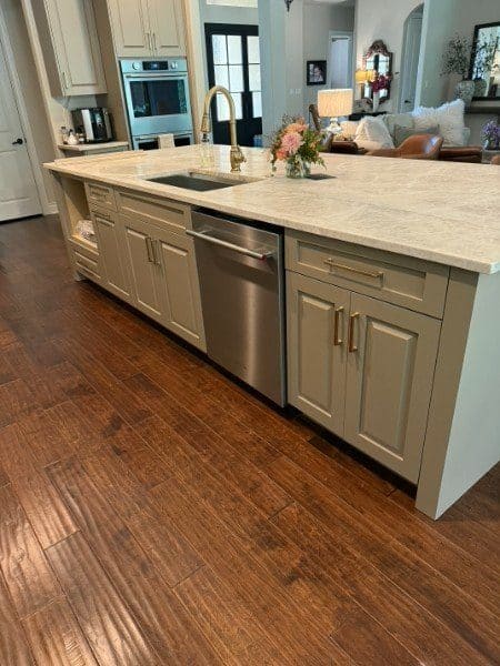 Kitchen island with quartzite countertop, brass faucet and custom cabinets by LuxeCraft
