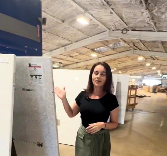 LuxeCraft team member showing a full stone slab to choose from in the San Antonio slab warehouse